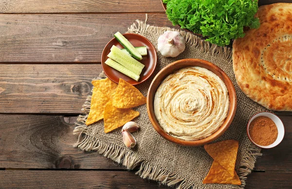 Wooden bowl of tasty hummus — Stock Photo, Image