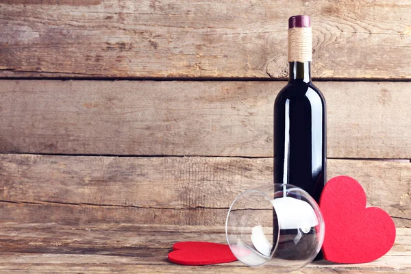 Красные сердца с бутылкой вина и бокалом — стоковое фото