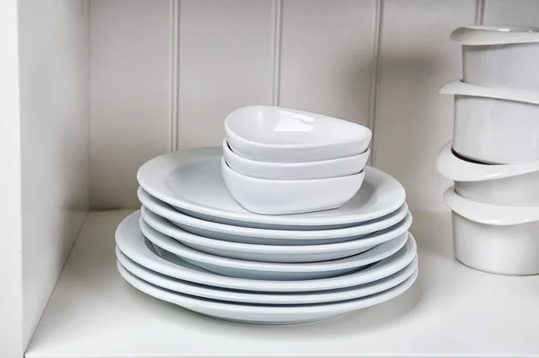 Dishes in cupboard in kitchen — Stock Photo, Image