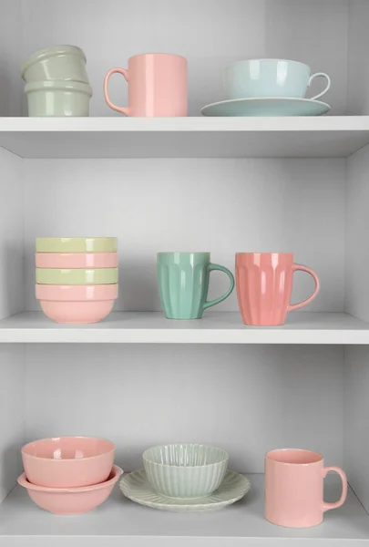 viele weiße Tassen und eine Rote Tasse auf dem Regal — Stockfoto