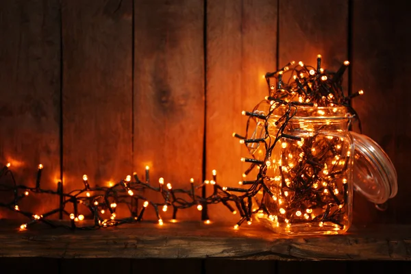 Glass jar with lighted garland — Stock Photo, Image