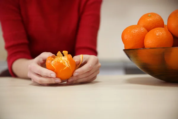 Woman peeling tangerine — Stock Photo, Image