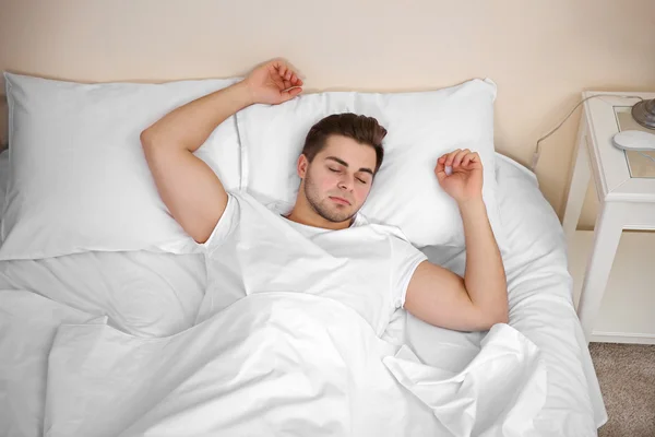 Junger Mann schläft im Bett — Stockfoto