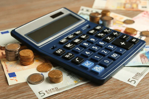 Calculator with banknotes and coins — Stock Photo, Image