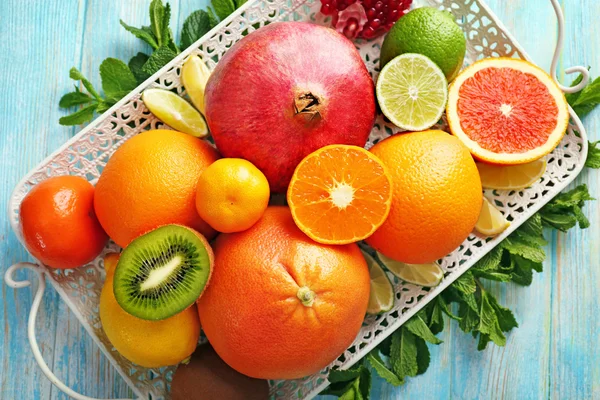 Composición jugosa de frutas tropicales en una bandeja sobre fondo de madera — Foto de Stock