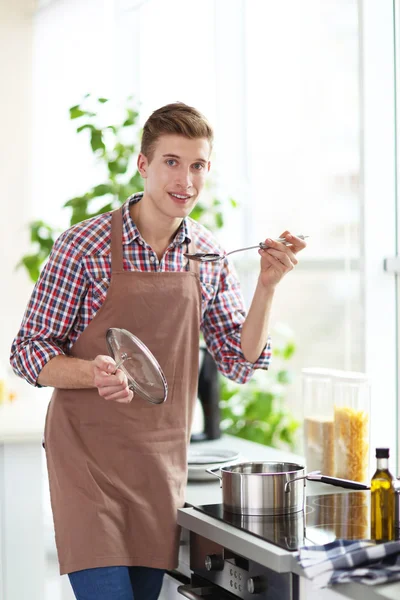 Uomo cucina cena in cucina luminosa — Foto Stock