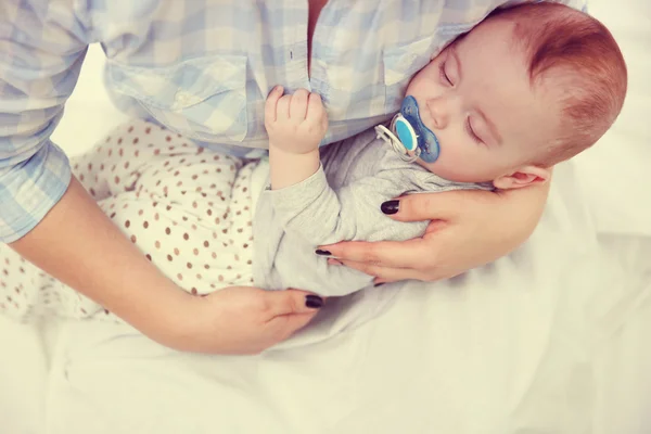 Baby mit Dummy schläft in den Händen der Mutter — Stockfoto