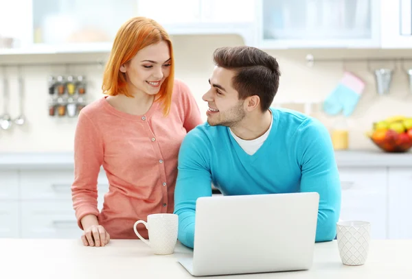 Couple avec tasse de thé à l'aide d'un ordinateur portable — Photo