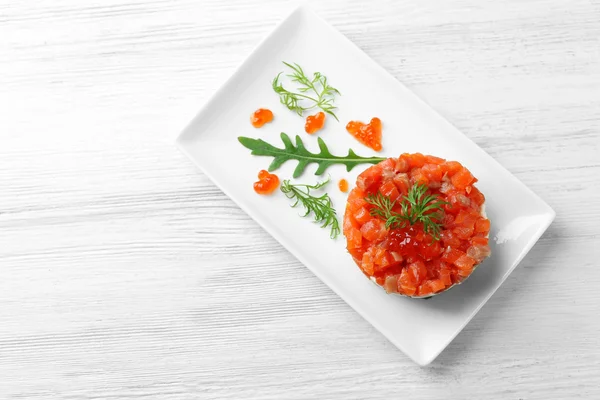 Beyaz plaka üzerinde kırmızı havyar ile lezzetli Somon tartar