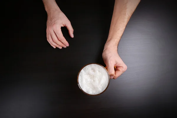 Manlig hand innehav glas öl — Stockfoto