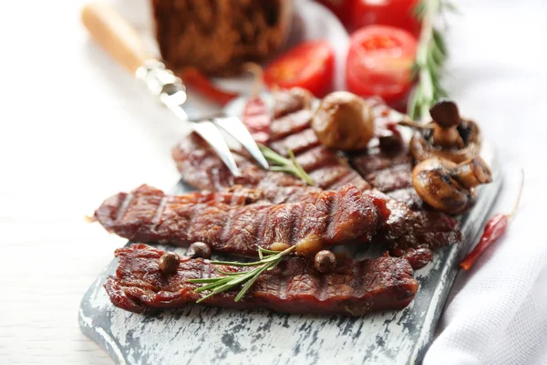 Carne a la parrilla con verduras en tabla de cortar — Foto de Stock