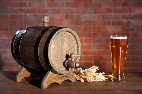 Vaso de cerveza ligera con barrica de madera y orejas de cebada sobre fondo de pared de ladrillo —  Fotos de Stock