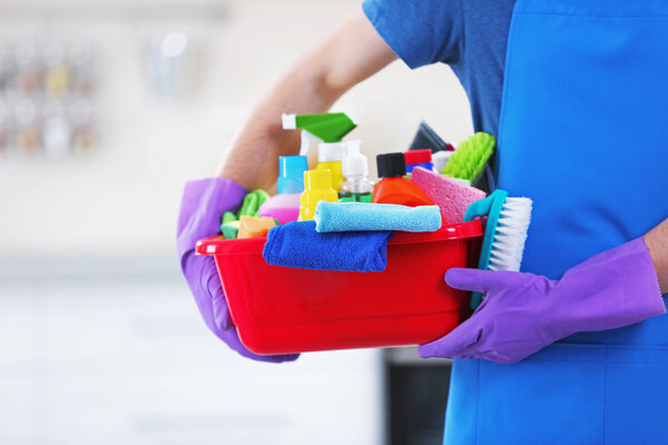 Человек держит раковину кисточками и перчатками
