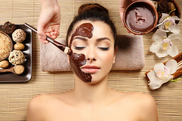 Menina bonita recebendo máscara de chocolate no salão de spa — Fotografia de Stock