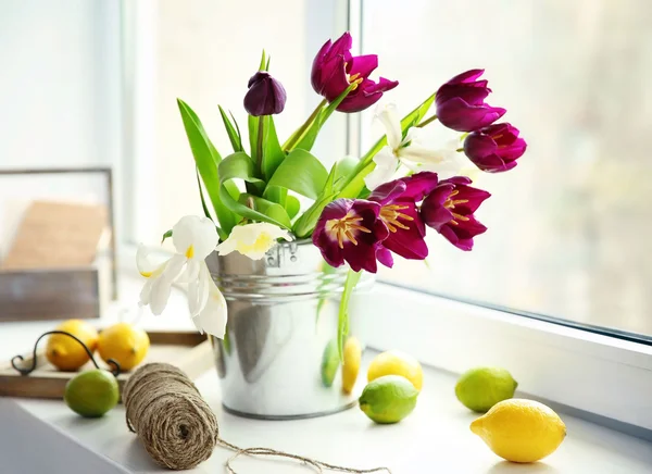 Ein Strauß violetter Tulpen in einem Metalleimer auf der Fensterbank, Nahaufnahme — Stockfoto