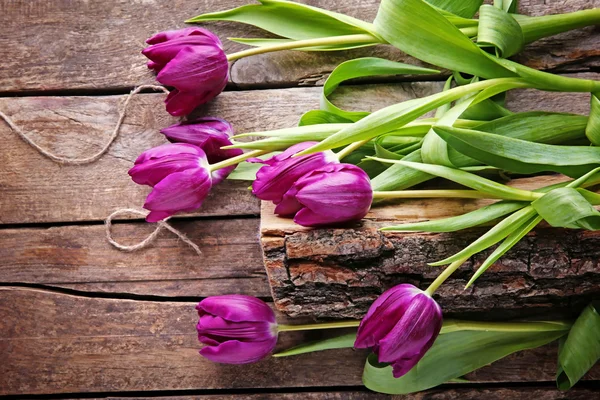 Tulipani viola freschi su sfondo di legno, vista dall'alto — Foto Stock