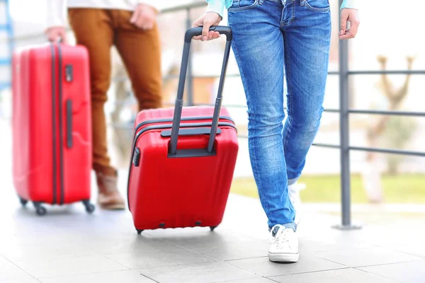 Couple rolling red suitcases — Stock Photo, Image