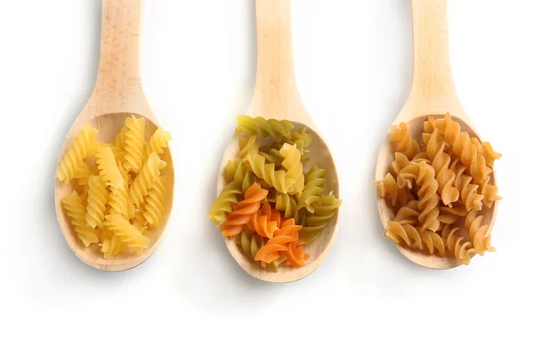 Muestras de pasta seca en cucharas de madera, aisladas en blanco —  Fotos de Stock