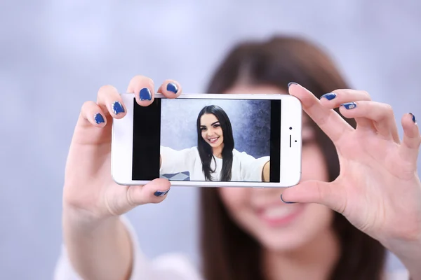 Chica haciendo foto por su cuenta con el teléfono móvil — Foto de Stock