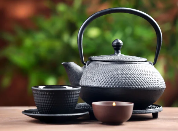 Black pialats and teapot on blurred background — Stock Photo, Image