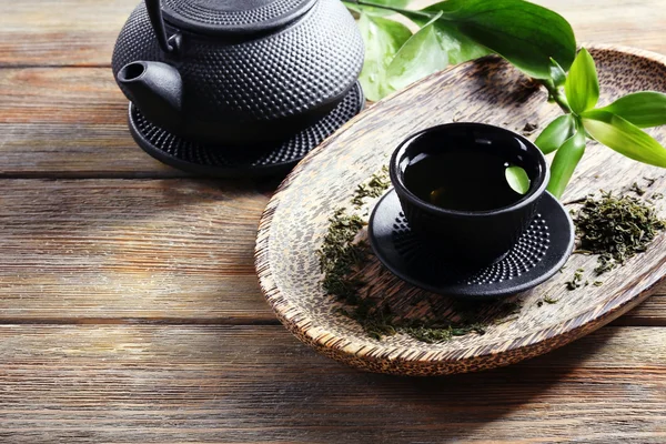 Chá verde com utensílios pretos na mesa de madeira — Fotografia de Stock
