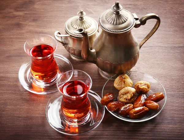 Schwarzer Tee in Glasbechern und orientalische Süßigkeiten auf Holztisch — Stockfoto