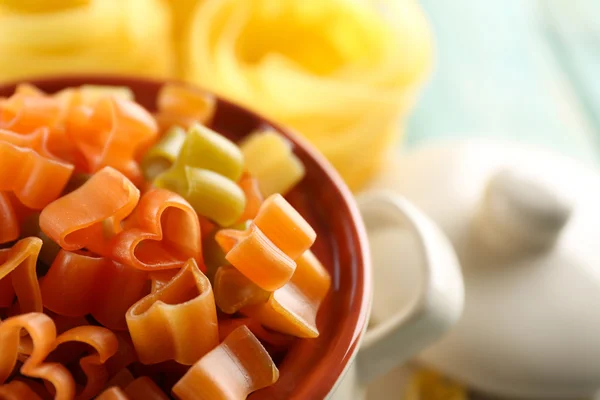 Olika typer av pasta i stekpanna på träbord närbild — Stockfoto