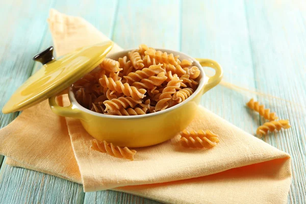 Raw pasta in pan on wooden background — Stock Photo, Image