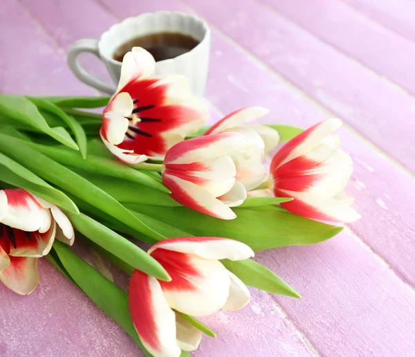 Bouquet aus bunten Tulpen mit Tasse Kaffee auf hölzernem Hintergrund — Stockfoto