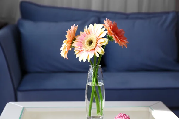 Ramo de gerberas rosadas sobre la mesa en la habitación — Foto de Stock