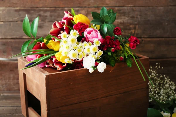 Boeket verse bloemen op een houten doos — Stockfoto