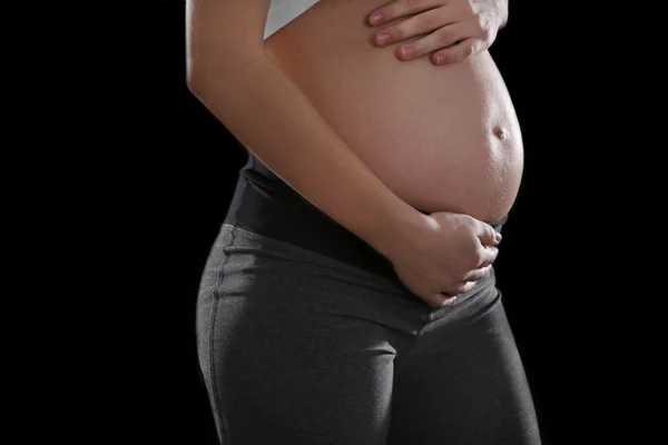 Mulher grávida no fundo preto — Fotografia de Stock