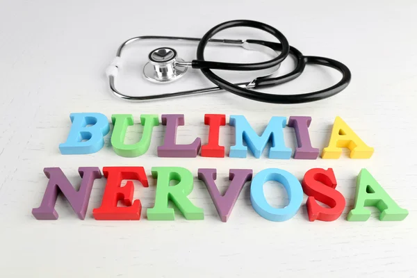 Bulimia nerviosa palabras coloridas y estetoscopio sobre fondo blanco . — Foto de Stock