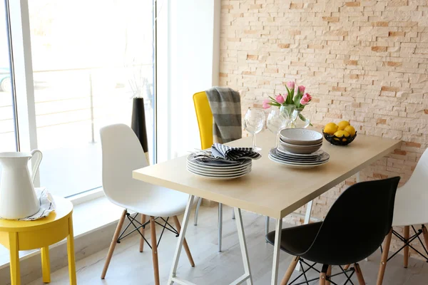 Mesa de comedor con platos y flores . — Foto de Stock