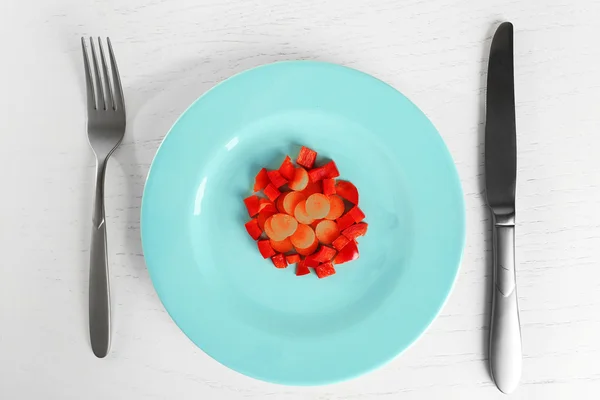 Тарелка с морковью и перцем на белом деревянном столе — стоковое фото