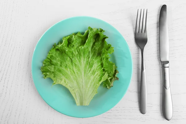 Beyaz ahşap masa salata yaprağı ile servis tabağı — Stok fotoğraf