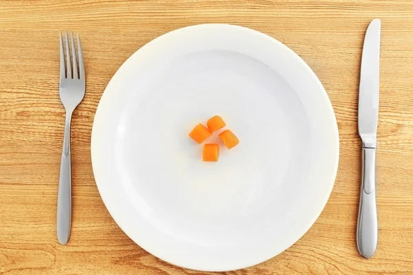 White plate with carrots  on wooden background — Stock Photo, Image