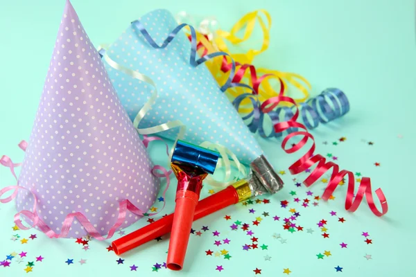 Sombreros de cumpleaños punteados con serpentina streamer y los fabricantes de ruido sobre fondo azul claro — Foto de Stock