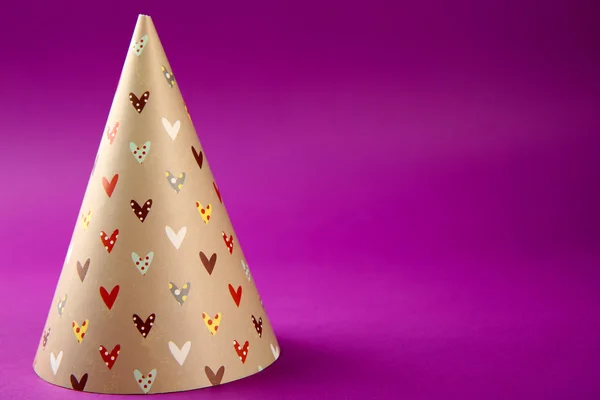 Birthday hat on purple background — Stock Photo, Image