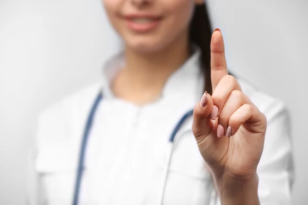 Jonge vrouwelijke arts met wijzende vinger — Stockfoto