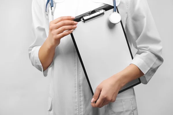 Läkare med pappershållare och stetoskop — Stockfoto