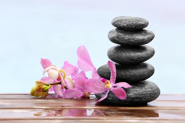 Wellness stones met roze orchideeën — Stockfoto