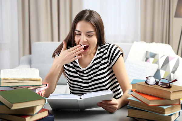 Женщина с книгами зевает — стоковое фото