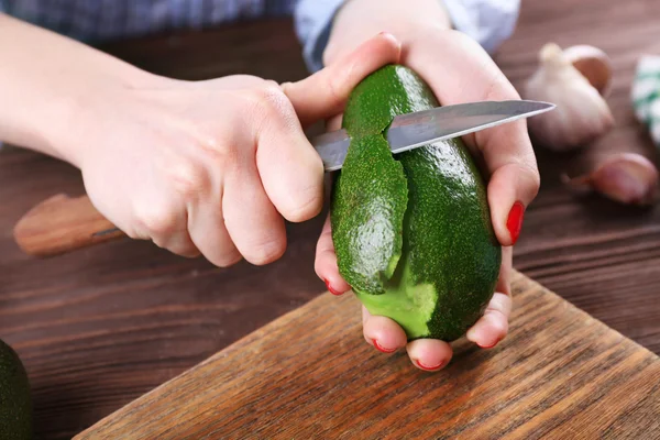 Hands peeling an avocado — Stock Photo, Image