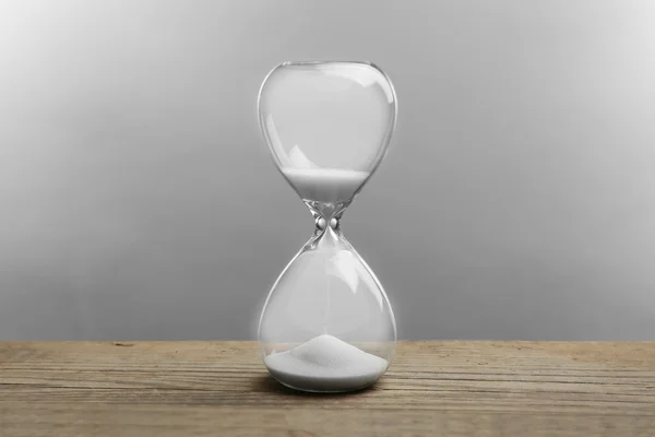 Hourglass on grey background — Stock Photo, Image