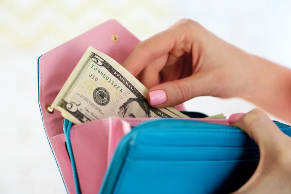 Young woman getting dollars banknote from purse — Stock Photo, Image