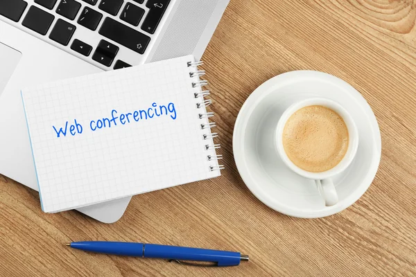 Webconferenties geschreven in notitieboekje, laptop en beker — Stockfoto