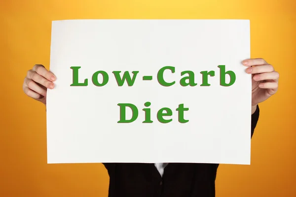 Mujer sosteniendo papel con texto de dieta baja en carbohidratos — Foto de Stock