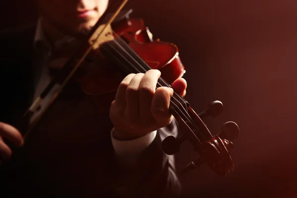 Músico toca violín sobre fondo oscuro — Foto de Stock