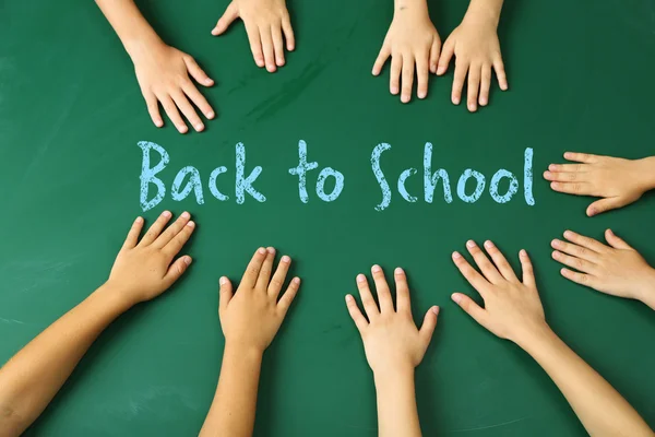 Children hands on blackboard — Stock Photo, Image